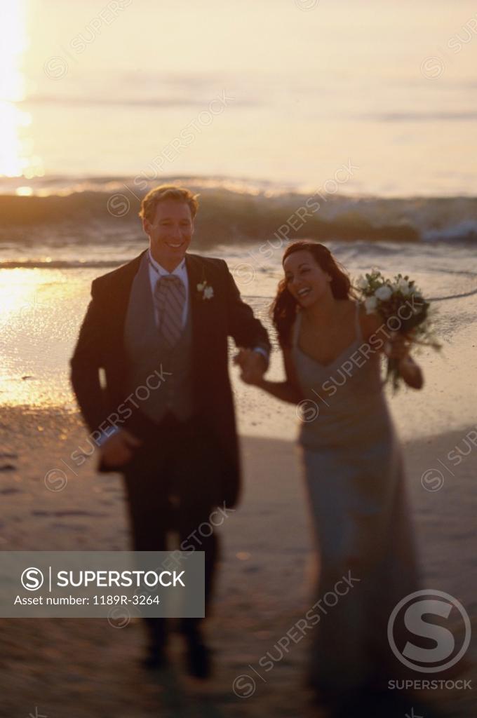 Stock Photo: 1189R-3264 Young couple walking on the beach