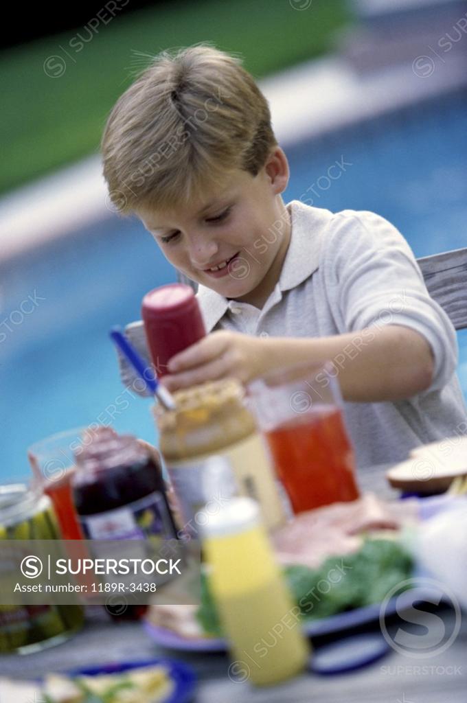 Stock Photo: 1189R-3438 Boy sitting at poolside