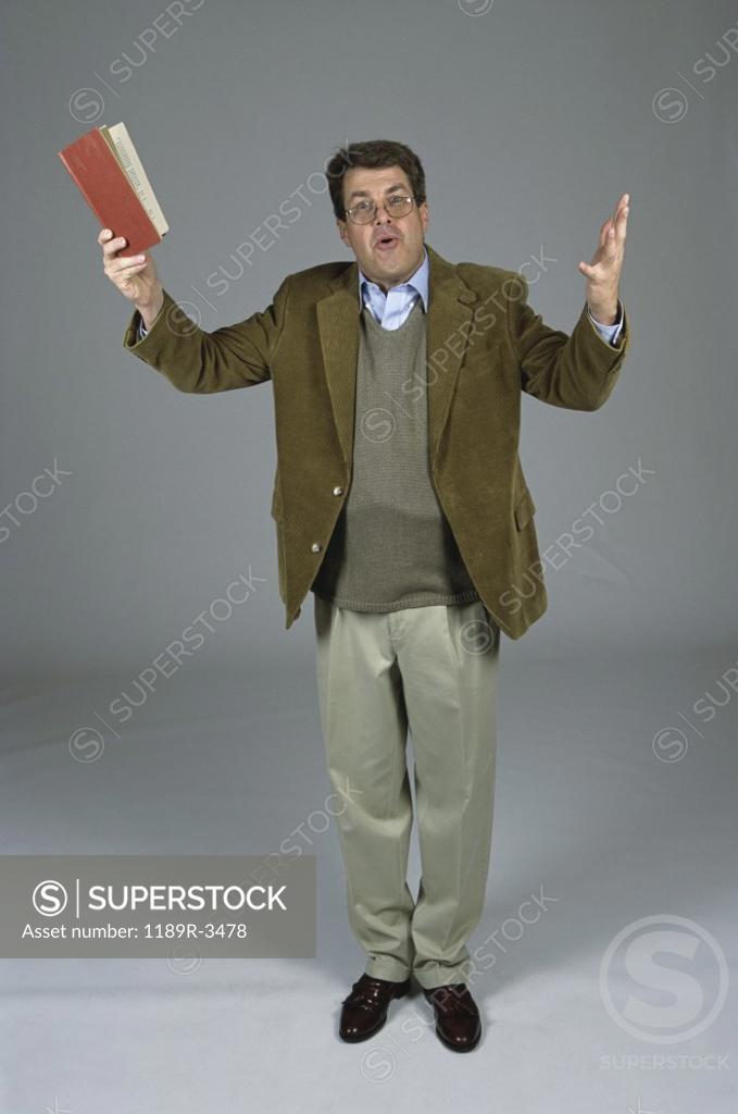 Stock Photo: 1189R-3478 Portrait of a male professor holding up a book
