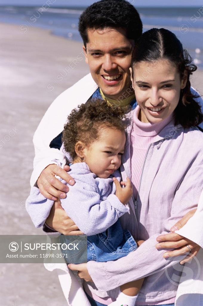 Stock Photo: 1189R-3571 Portrait of a father and mother on the beach with their daughter