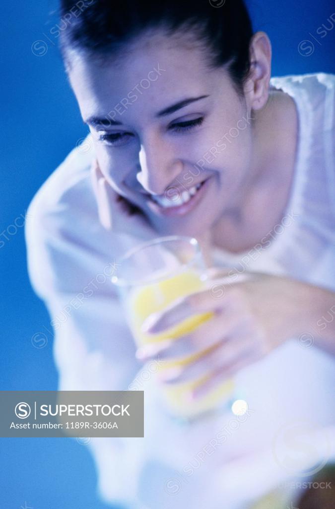 Stock Photo: 1189R-3606A High angle view of a young woman holding a glass of orange juice