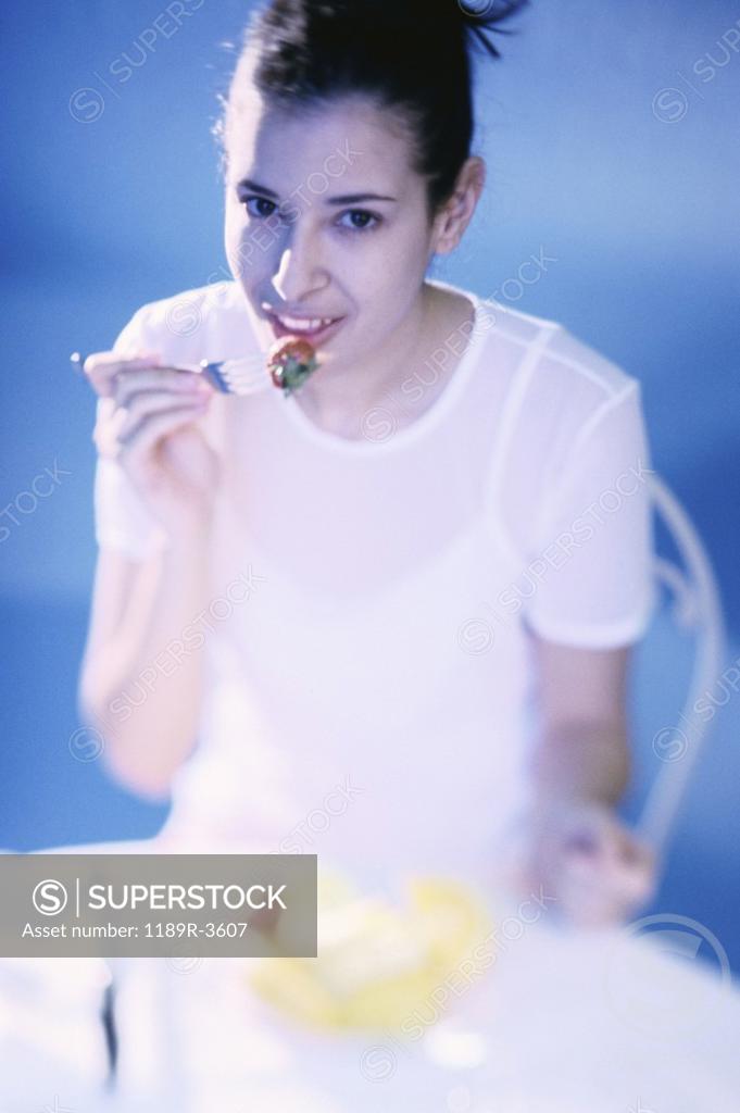 Stock Photo: 1189R-3607 Portrait of a young woman eating a strawberry