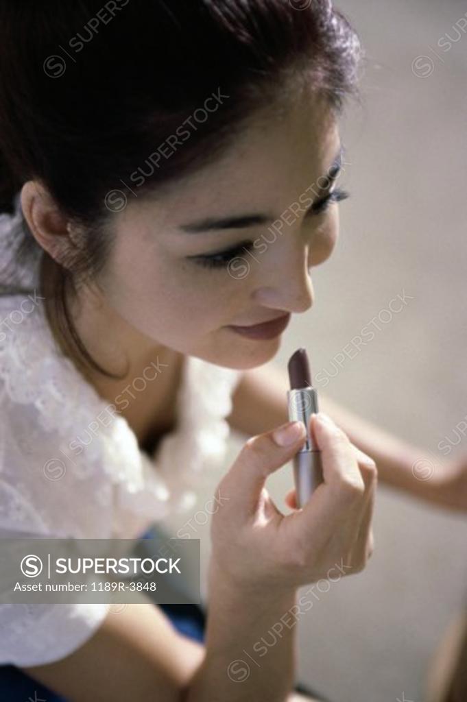 Stock Photo: 1189R-3848 High angle view of a young woman applying lipstick