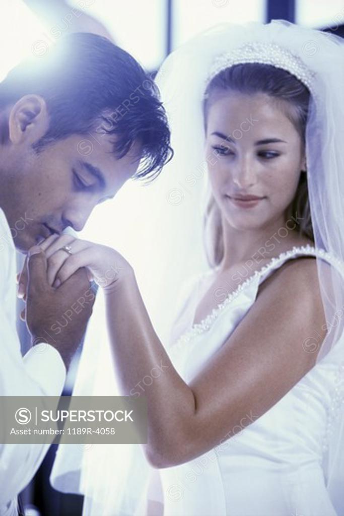 Stock Photo: 1189R-4058 Groom kissing his brides hand