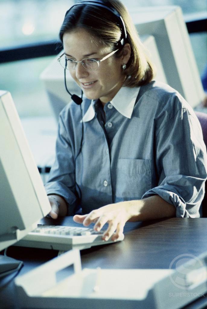 Businesswoman wearing a headset working on a computer