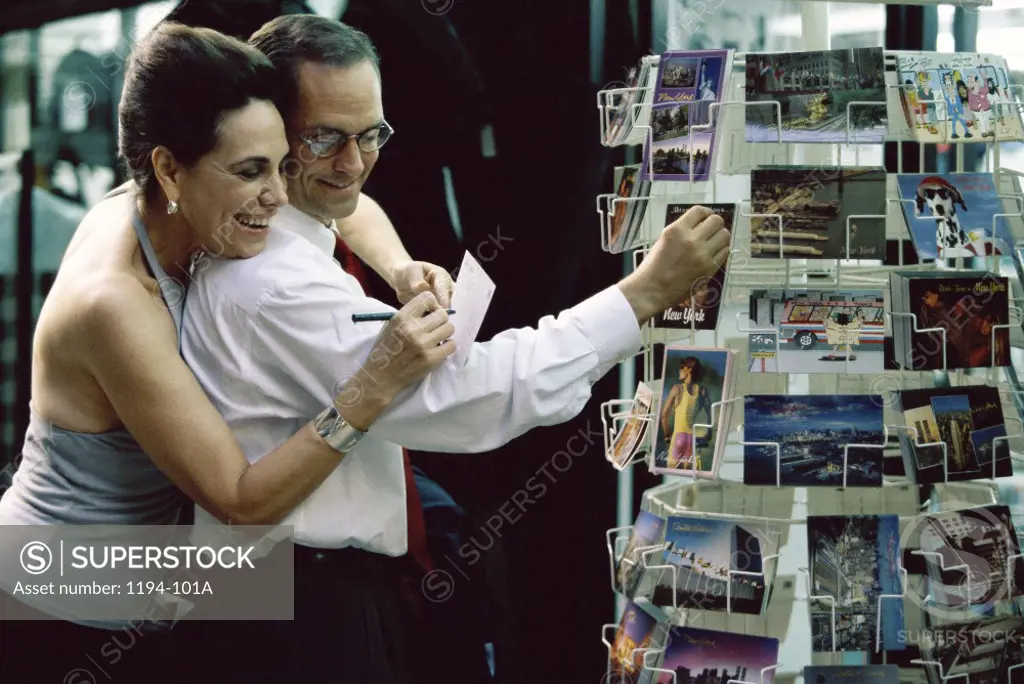 Mid adult couple looking at postcards in a store