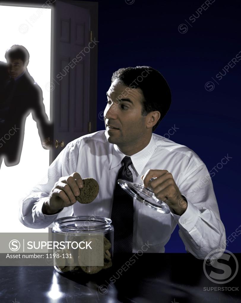 Stock Photo: 1198-131 Businessman caught with his hand in the cookie jar
