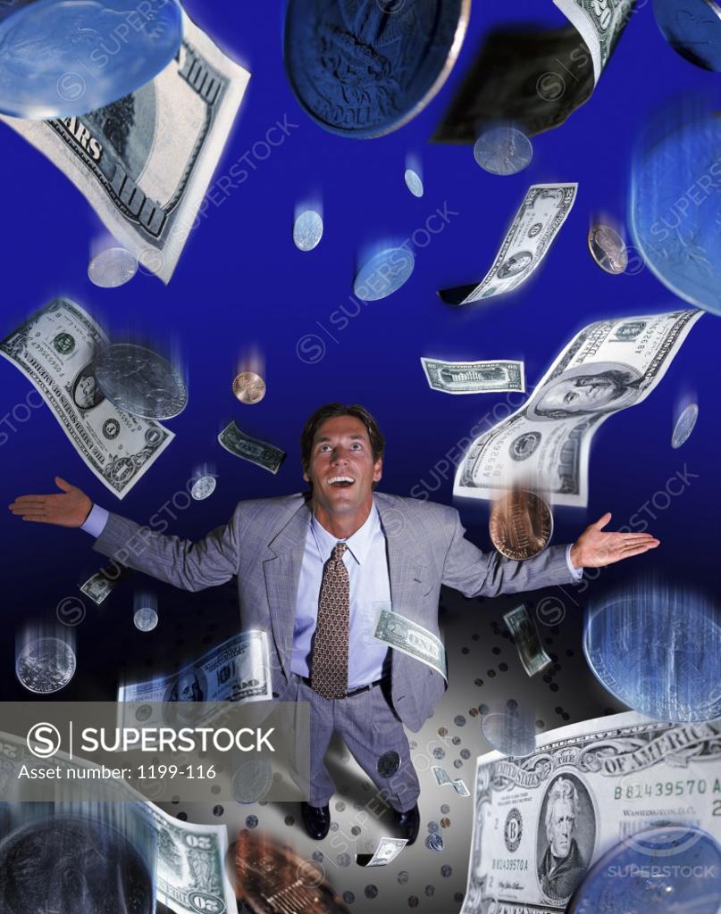Stock Photo: 1199-116 American dollar bills and coins raining down on a businessman