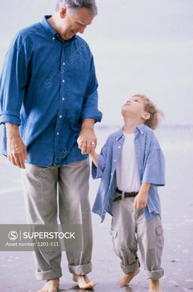 Stock Photo: 1201-111 Grandfather and his grandson walking on the beach