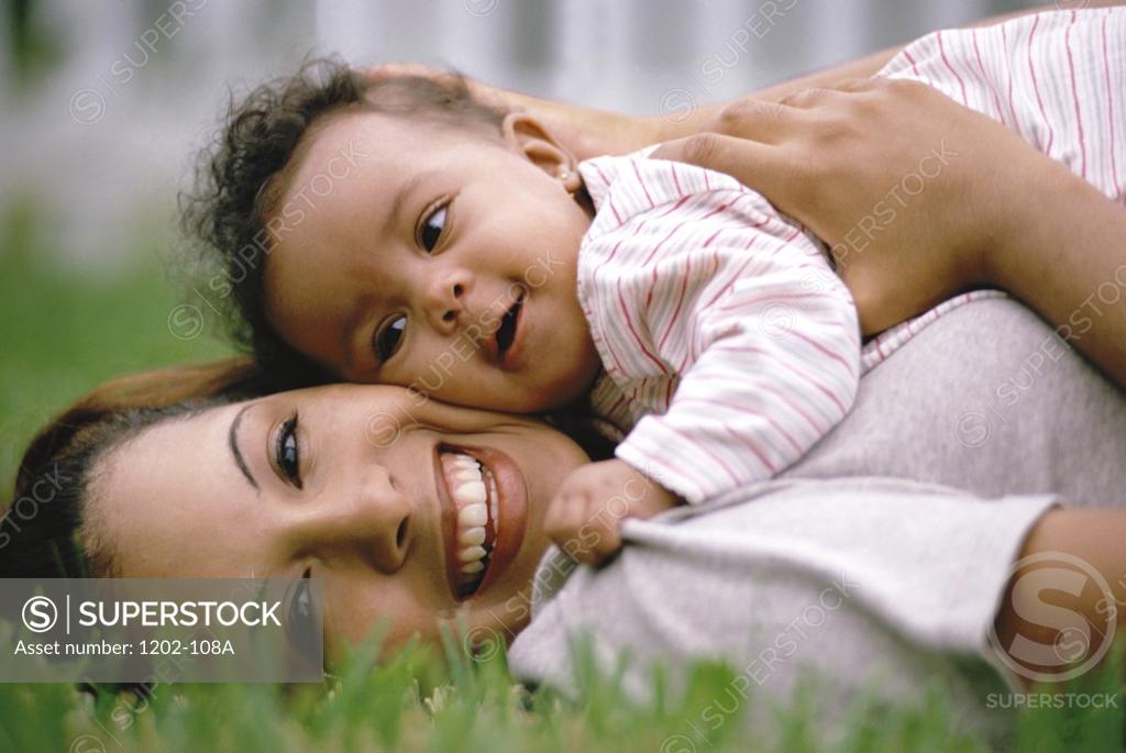 Stock Photo: 1202-108A Close-up of a mother lying on the lawn with her baby boy
