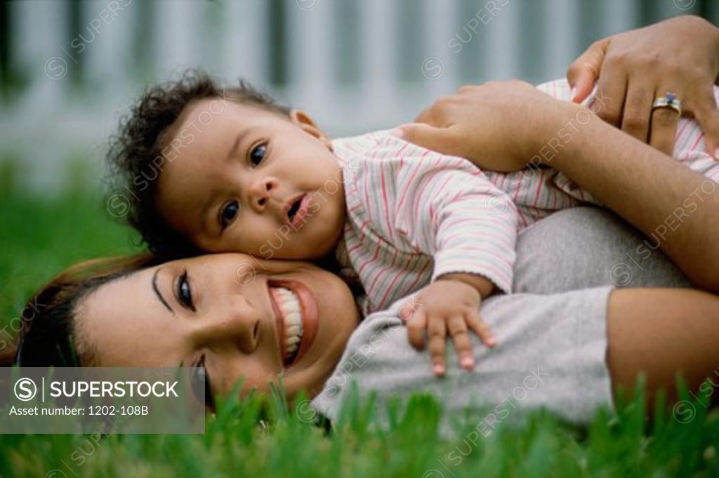 Stock Photo: 1202-108B Portrait of a mid adult woman lying on grass with her son