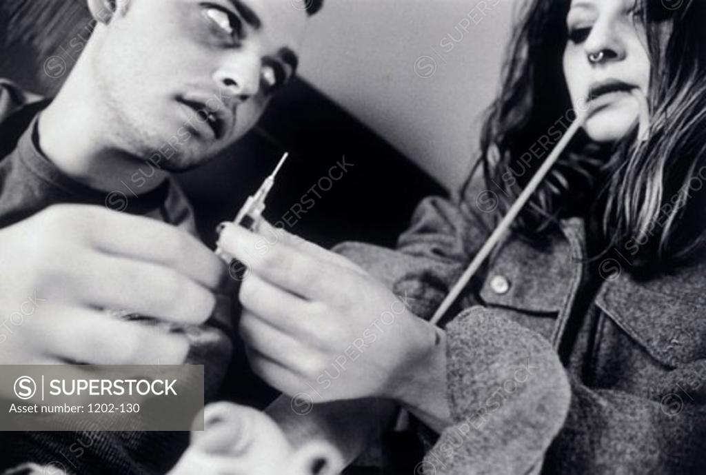 Stock Photo: 1202-130 Close-up of a young man giving a narcotic injection to a young woman