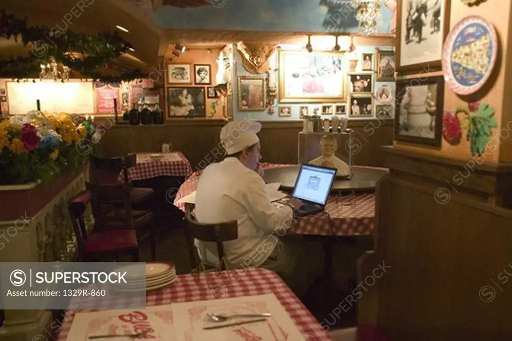 Side profile of a chef using a laptop in a restaurant