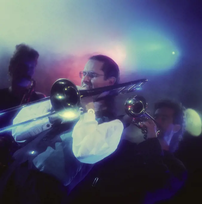 Pop musician playing a trombone in a nightclub
