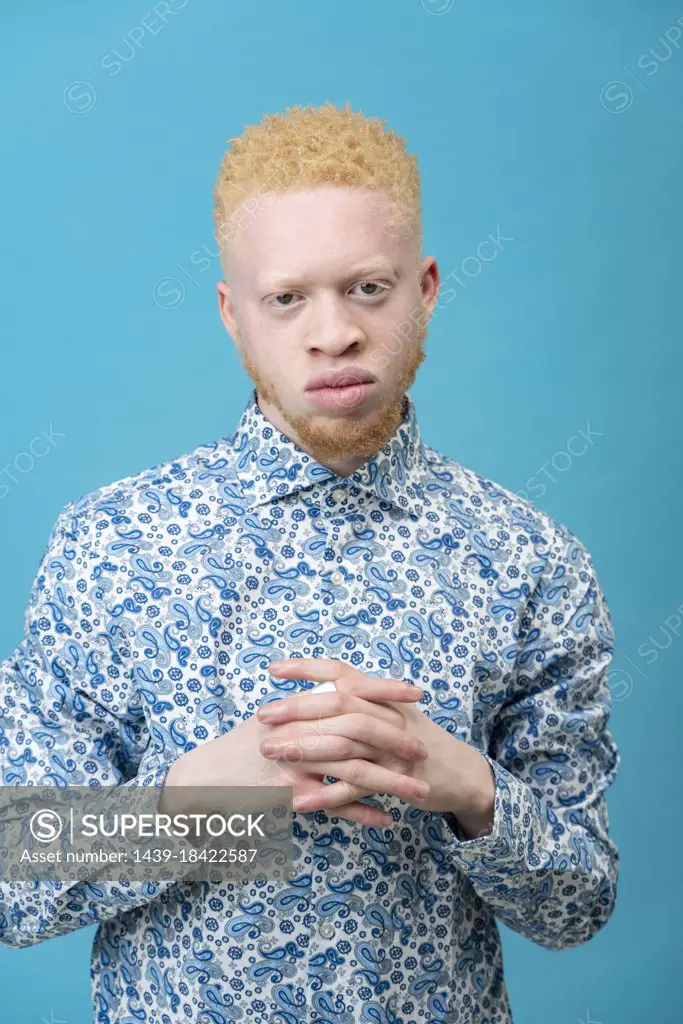 Studio portrait of albino man in blue patterned shirt
