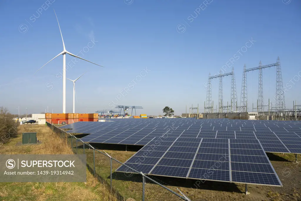 Netherlands, Solar farm and wind turbines in harbor