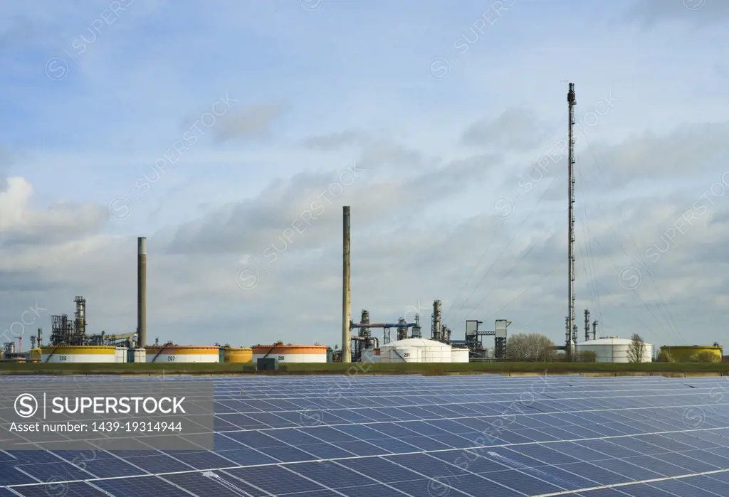 Netherlands, Newly built solar farm in front of oil refinery