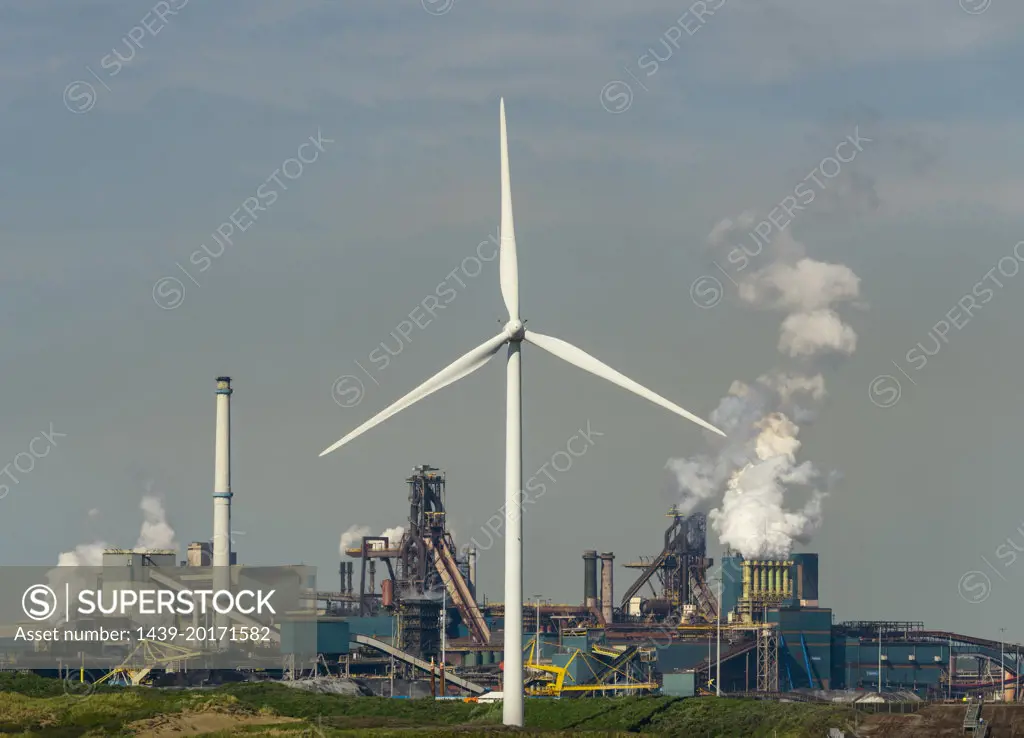 Netherlands, IJmuiden, Wind turbine in front of steel mill