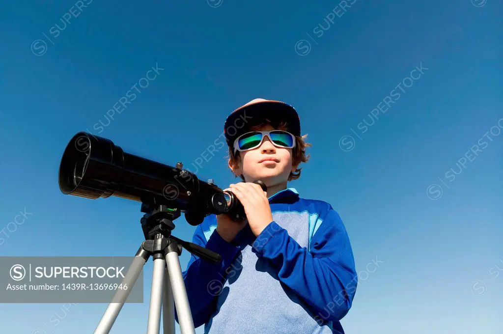 Boy with telescope on tripod