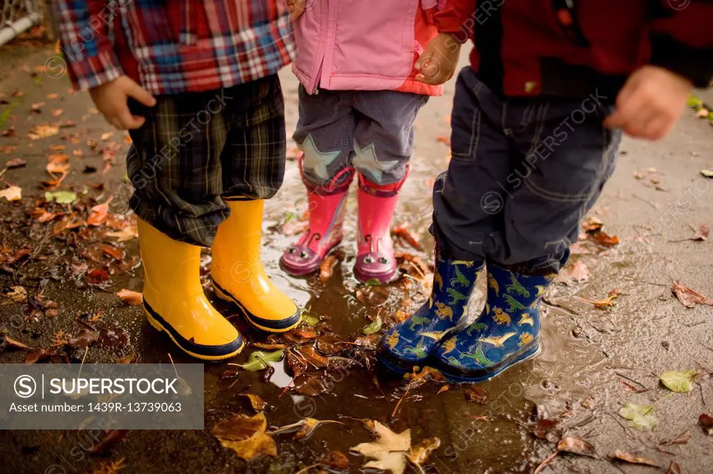 Three children wearing wellington boots