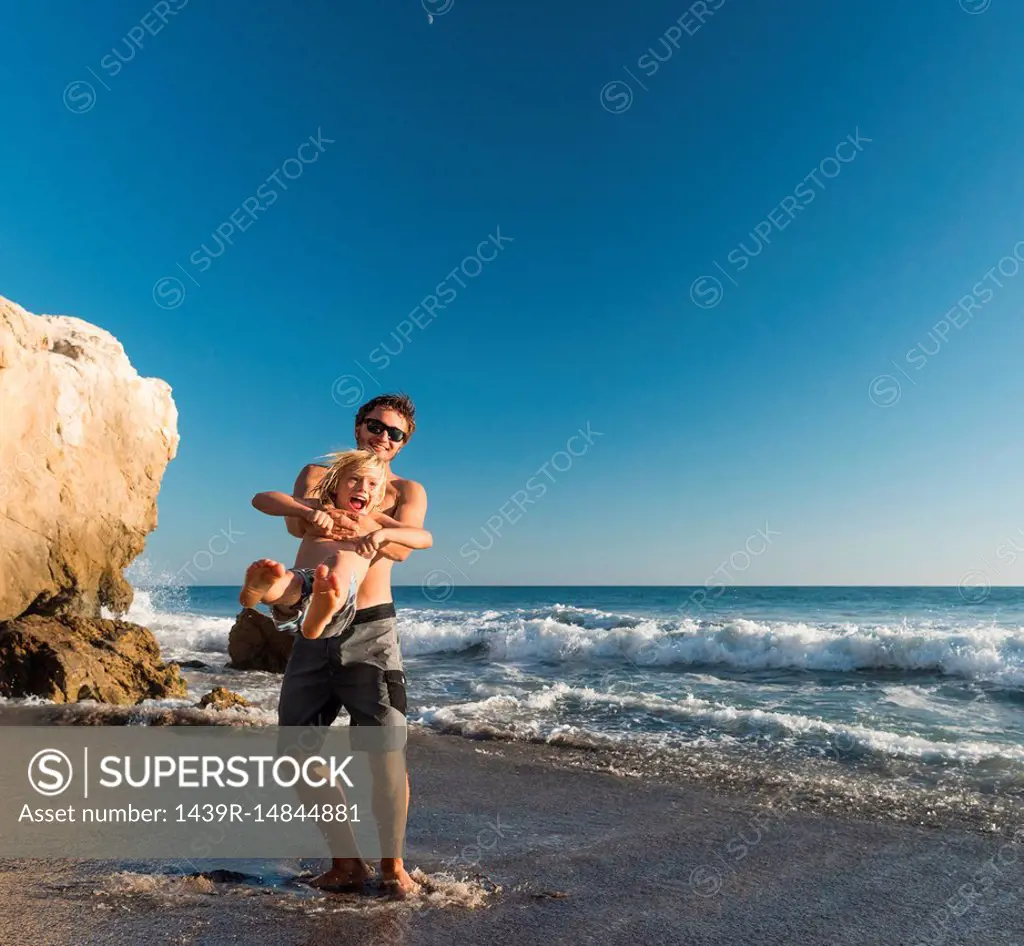 Brothers playing on El Matador Beach, Malibu, USA