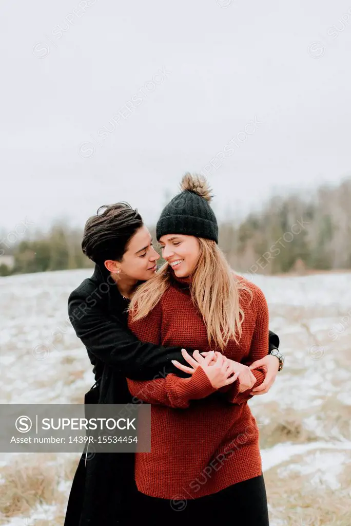 Couple hugging in snowy landscape, Georgetown, Canada