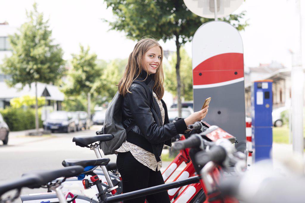 Young woman using bike sharing system