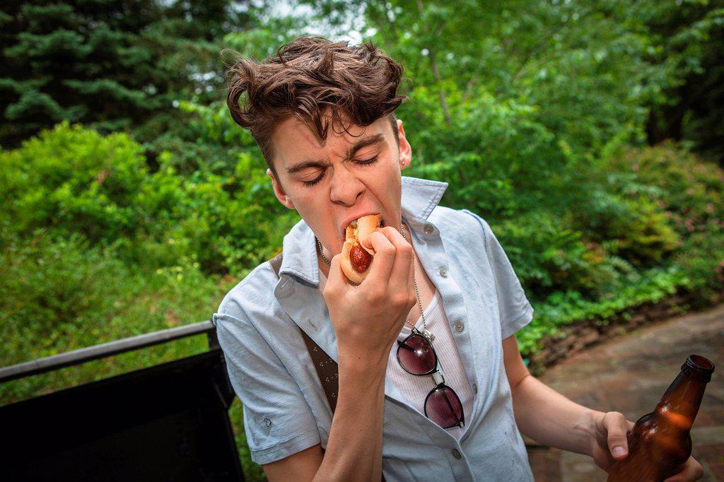 Young man eating a hotdog
