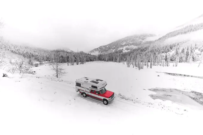 Camper van travelling through snow, Lillooet Lake, British Columbia, Canada
