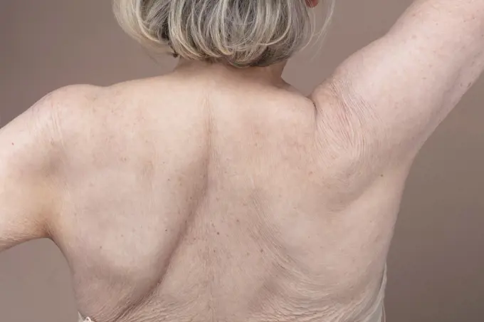 Rear view of shirtless senior woman