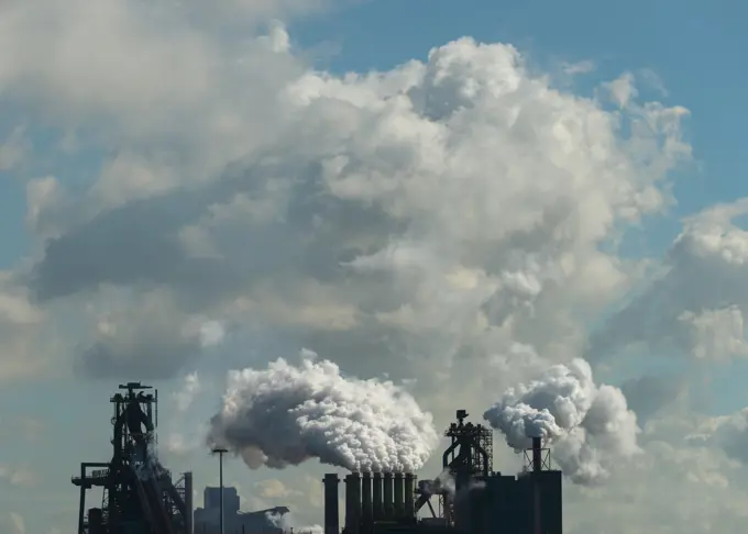 Netherlands, IJmuiden, Clouds above steel mill emitting steam