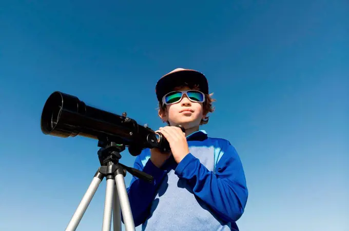 Boy with telescope on tripod