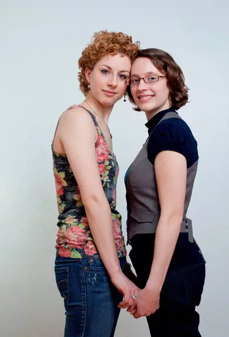 Portrait of lesbian couple holding hands, studio shot