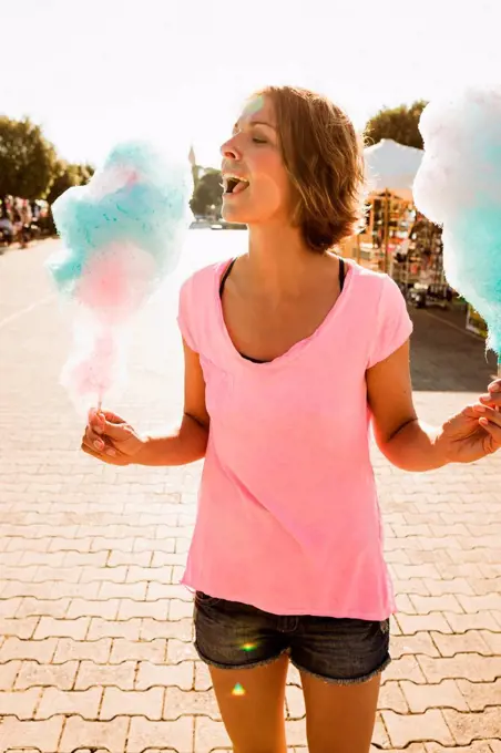 Woman eating cotton candy outdoors