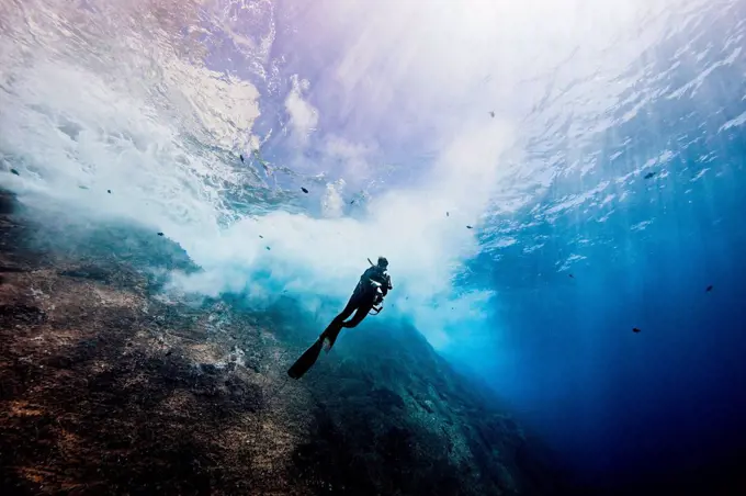 Underwater view of female diver exploring roca partida pinnacle, Socorro, Baja California, Mexico
