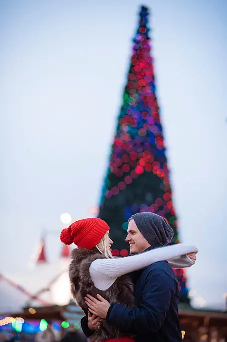 Romantic young couple hugging at xmas festival in Hyde Park, London, UK