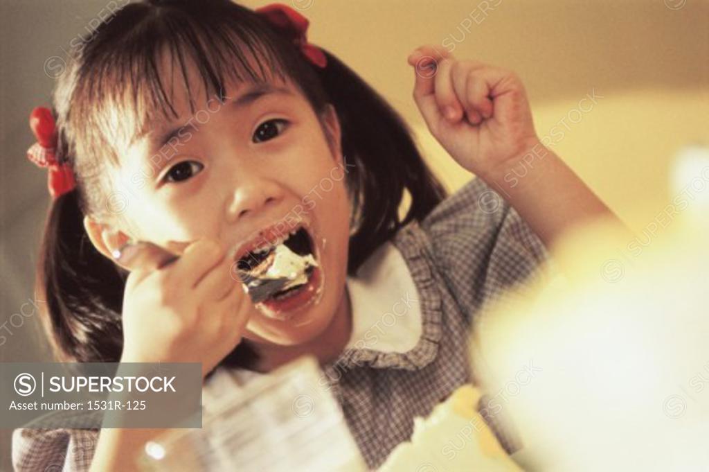Stock Photo: 1531R-125 Portrait of a girl eating with a spoon