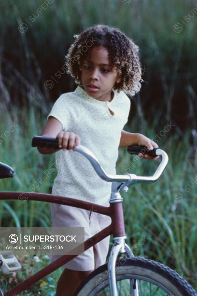 Stock Photo: 1531R-136 Girl walking holding a bicycle