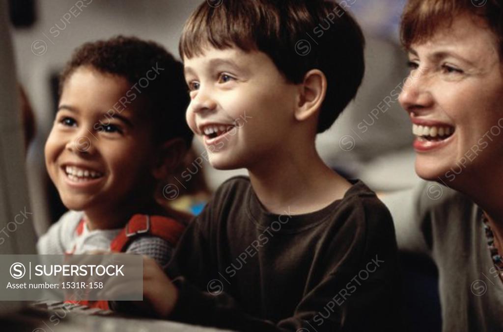 Stock Photo: 1531R-158 Female teacher in front of a computer monitor with two boys