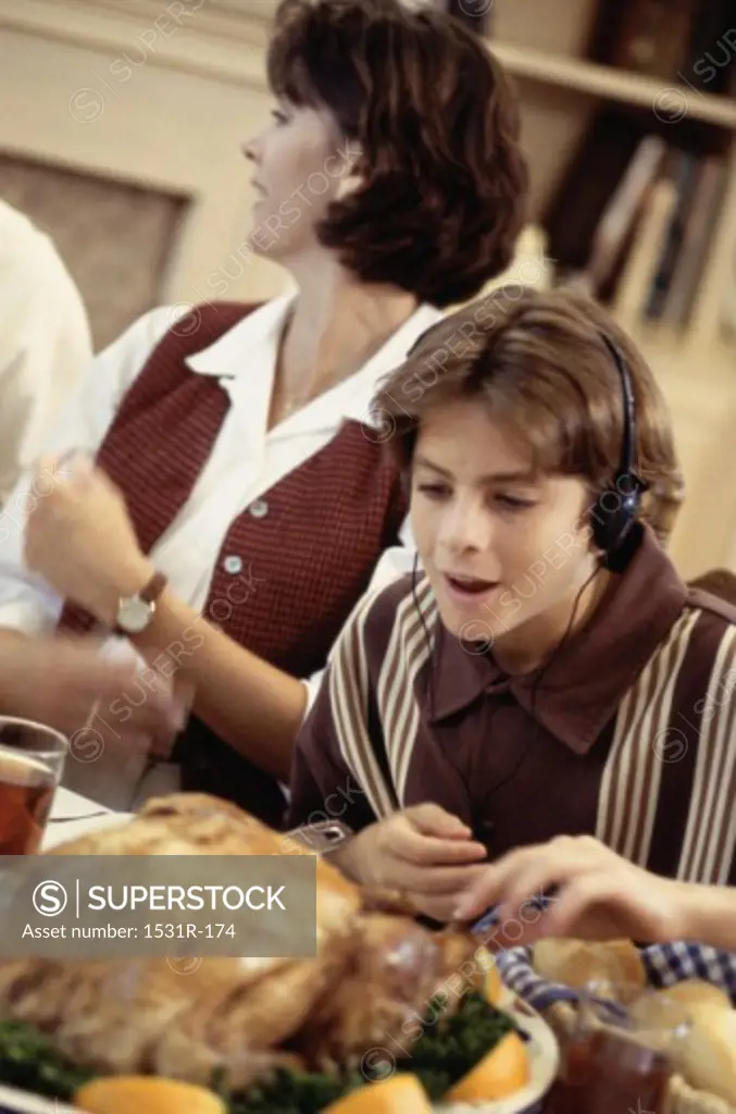 Boy sitting at a dining table wearing headphones