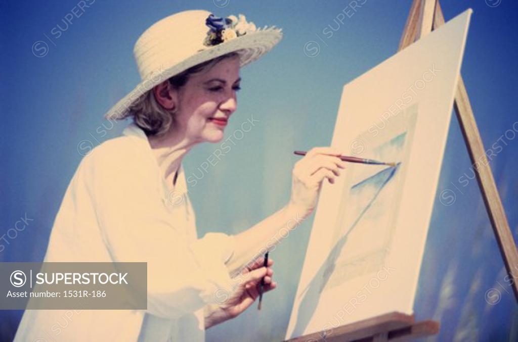 Stock Photo: 1531R-186 Mature woman painting on an easel