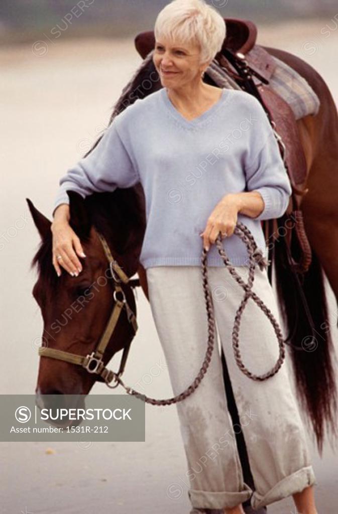 Stock Photo: 1531R-212 Senior woman standing with a horse