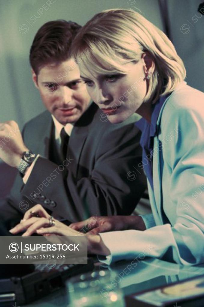 Stock Photo: 1531R-256 Businessman and a businesswoman working on a laptop