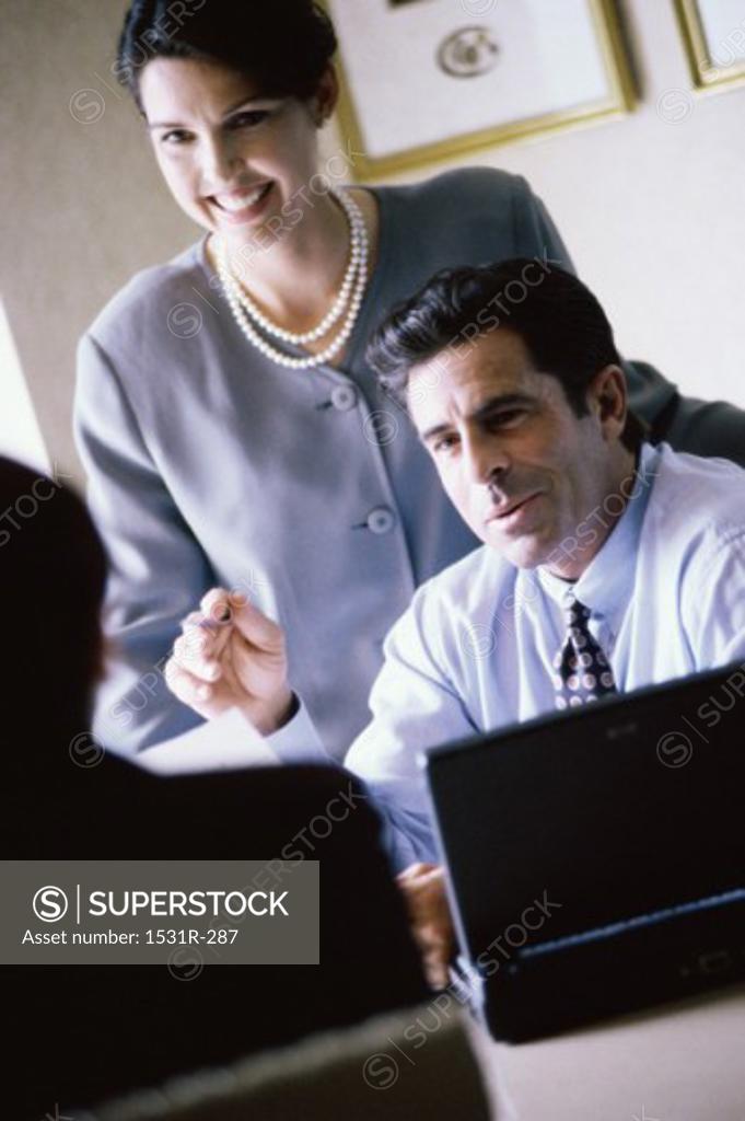 Stock Photo: 1531R-287 Businessman and a businesswoman smiling in an office