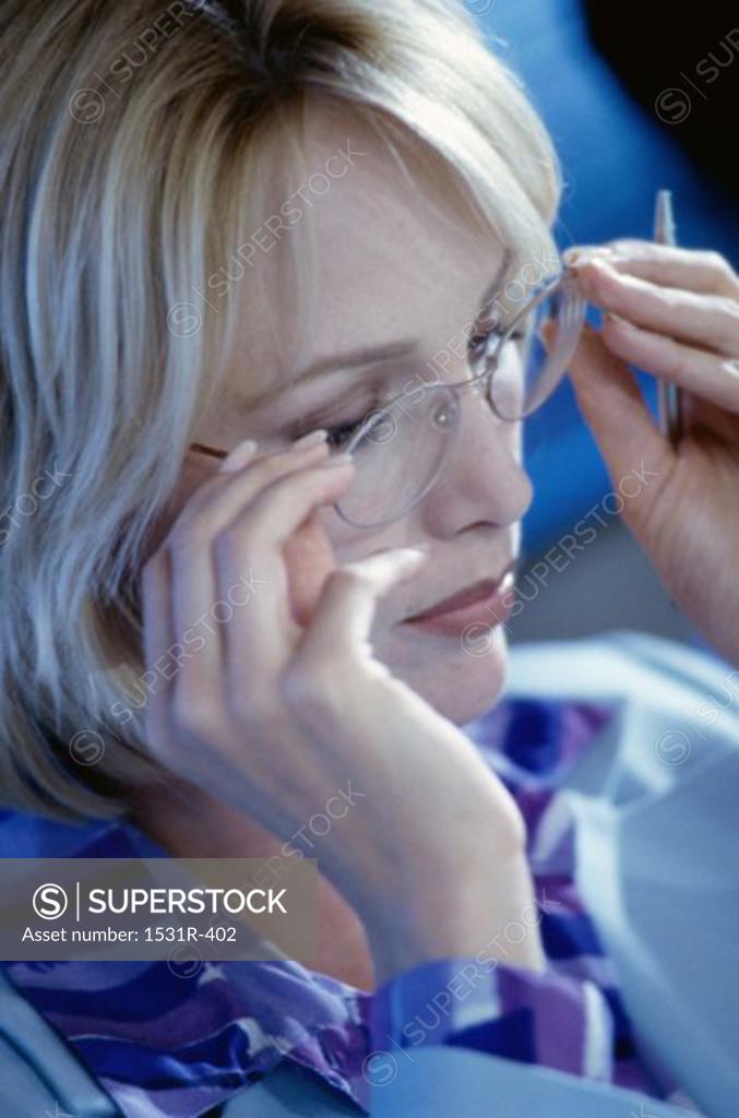 Stock Photo: 1531R-402 Businesswoman adjusting her eyeglasses