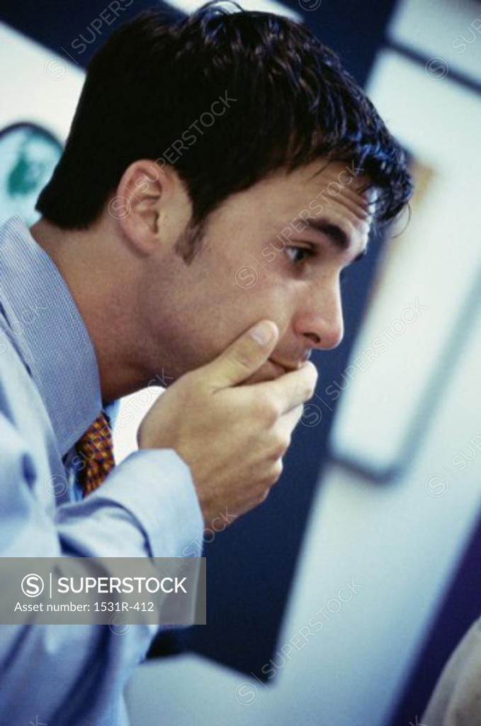 Stock Photo: 1531R-412 Side profile of a businessman with his hand on chin