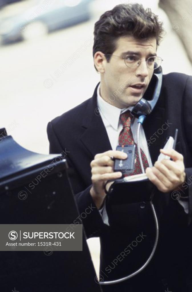 Stock Photo: 1531R-431 Businessman talking on a pay phone