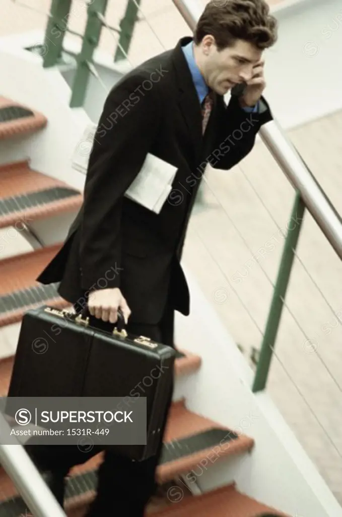 Side profile of a businessman talking on a mobile phone holding a briefcase