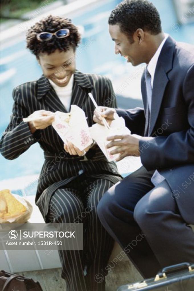 Stock Photo: 1531R-450 Businesswoman and a businessman eating Chinese takeout food