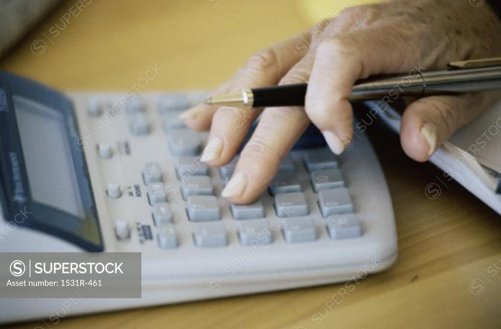 Stock Photo: 1531R-461 Close-up of a person's hand on a calculator